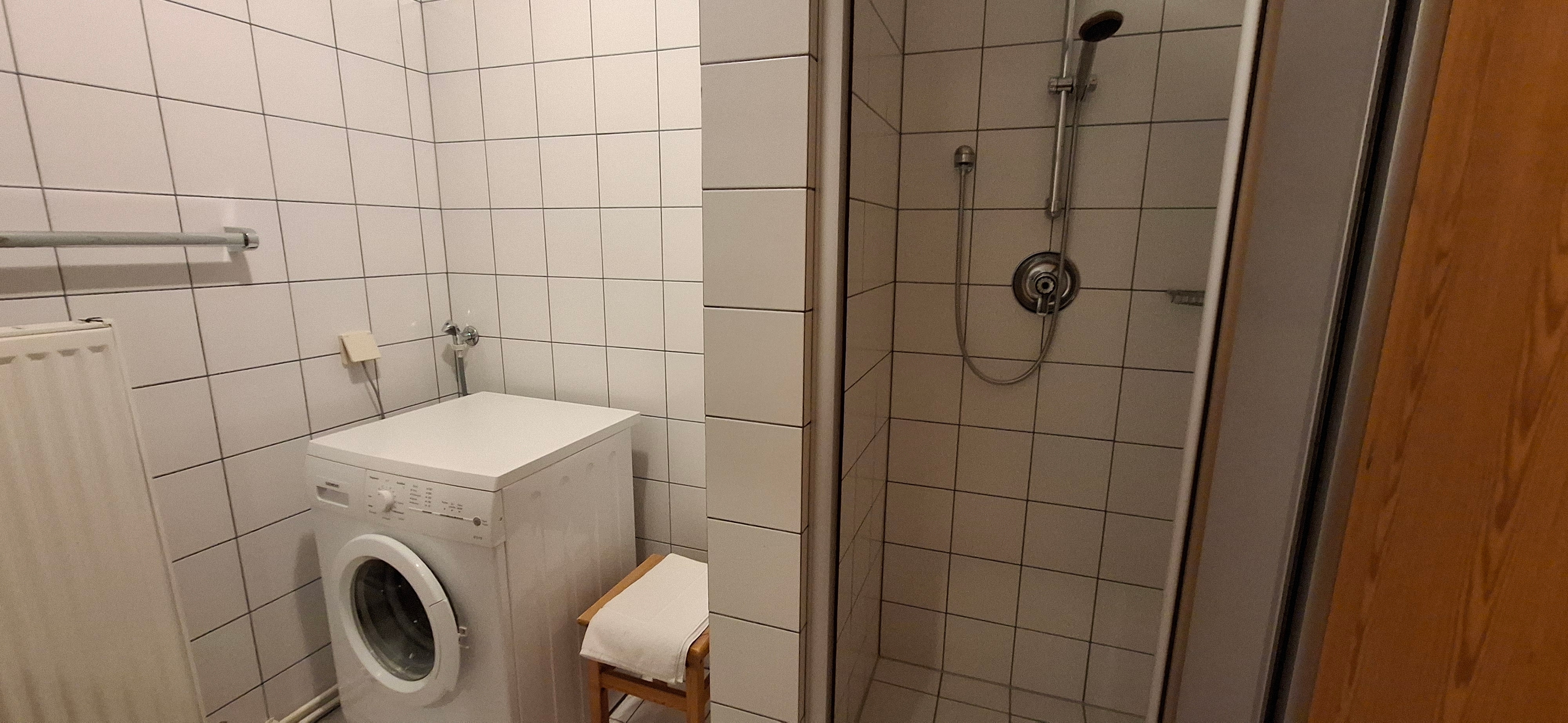 Badezimmer mit Dusche und Waschmaschine