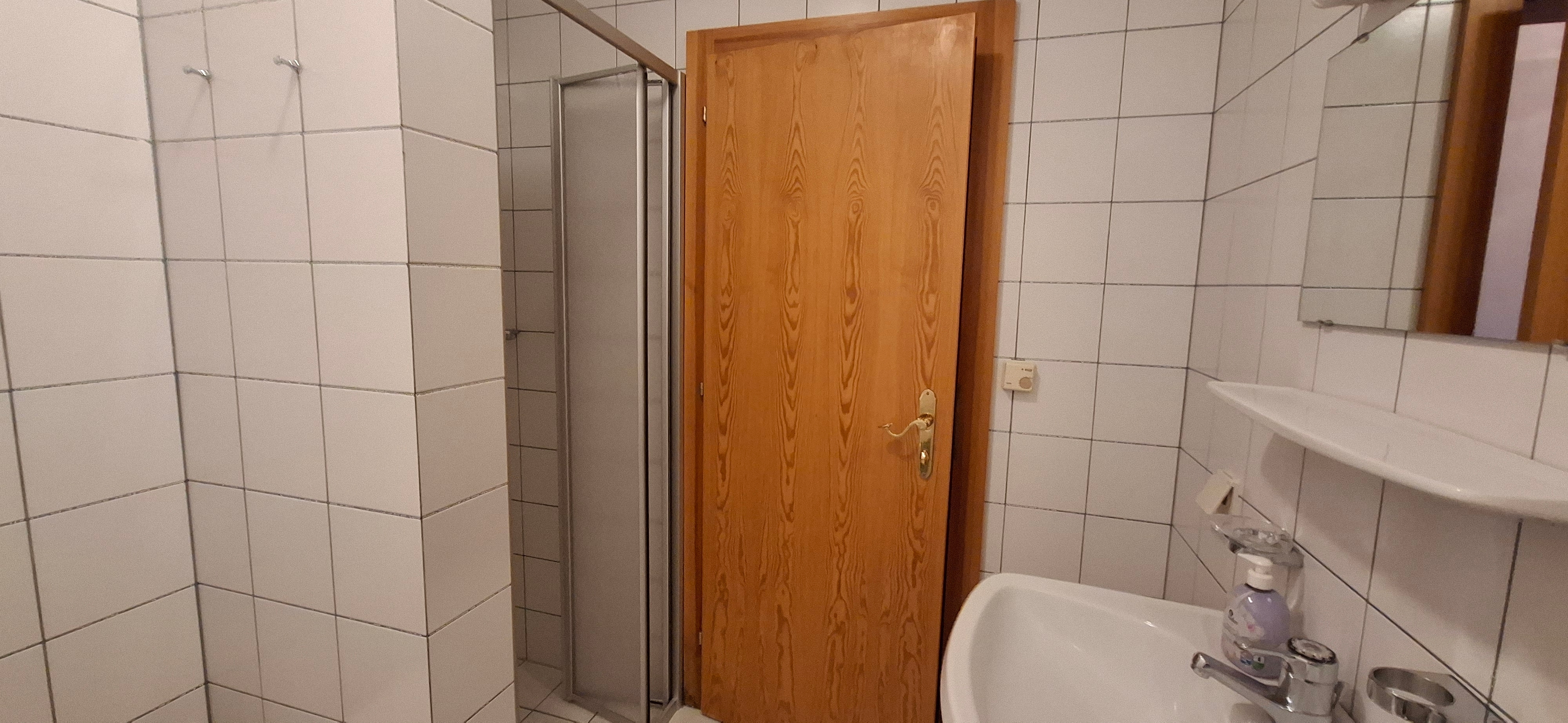 Badezimmer mit Dusche und Waschmaschine