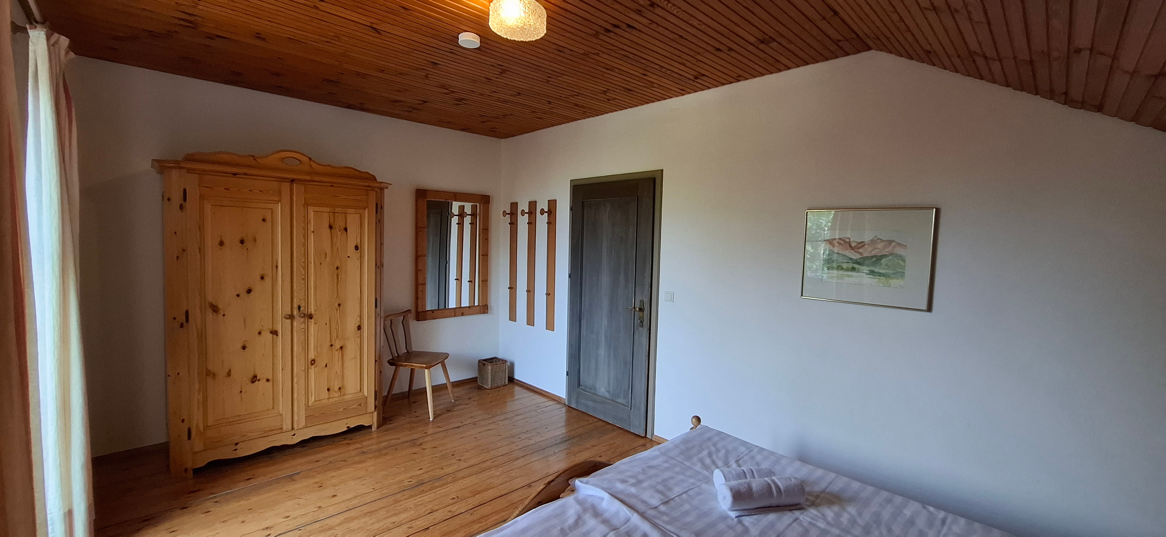 Schlafzimmer mit Doppelbett und Balkon im Obergeschoß