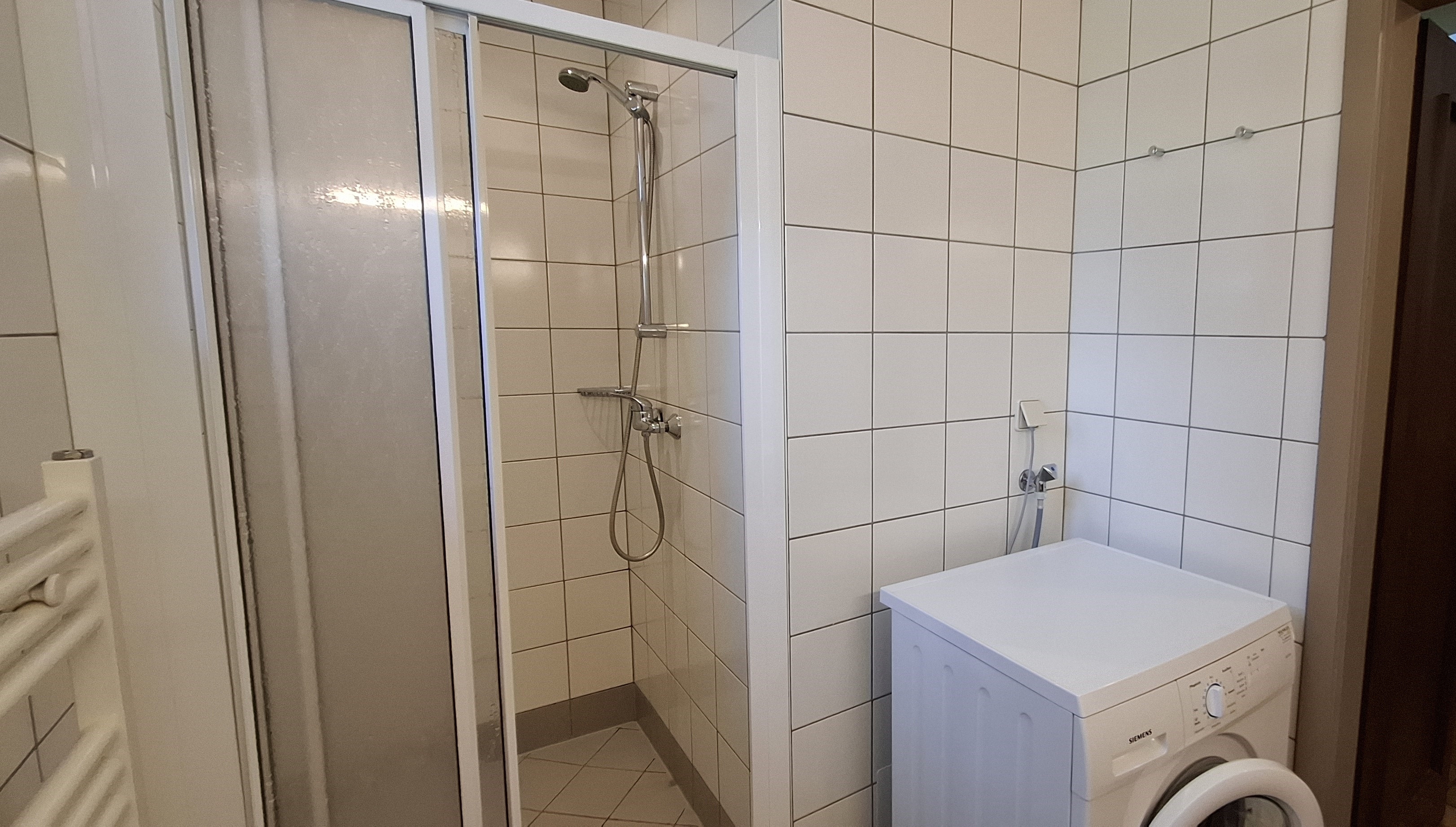 Badezimmer mit Dusche, Doppelwaschbecken und Waschmaschine im Erdgeschoß