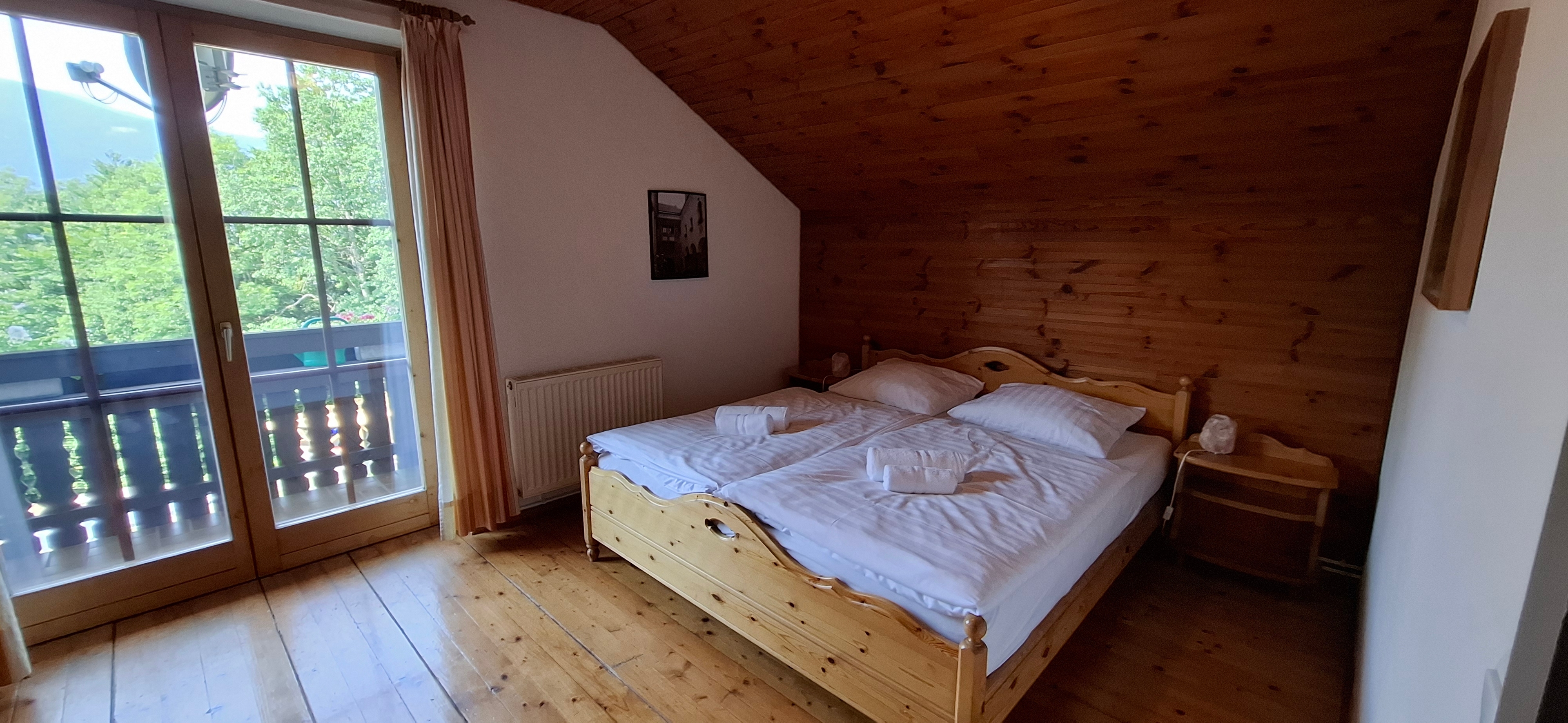 Schlafzimmer mit Balkon und Doppelbett im Obergeschoß