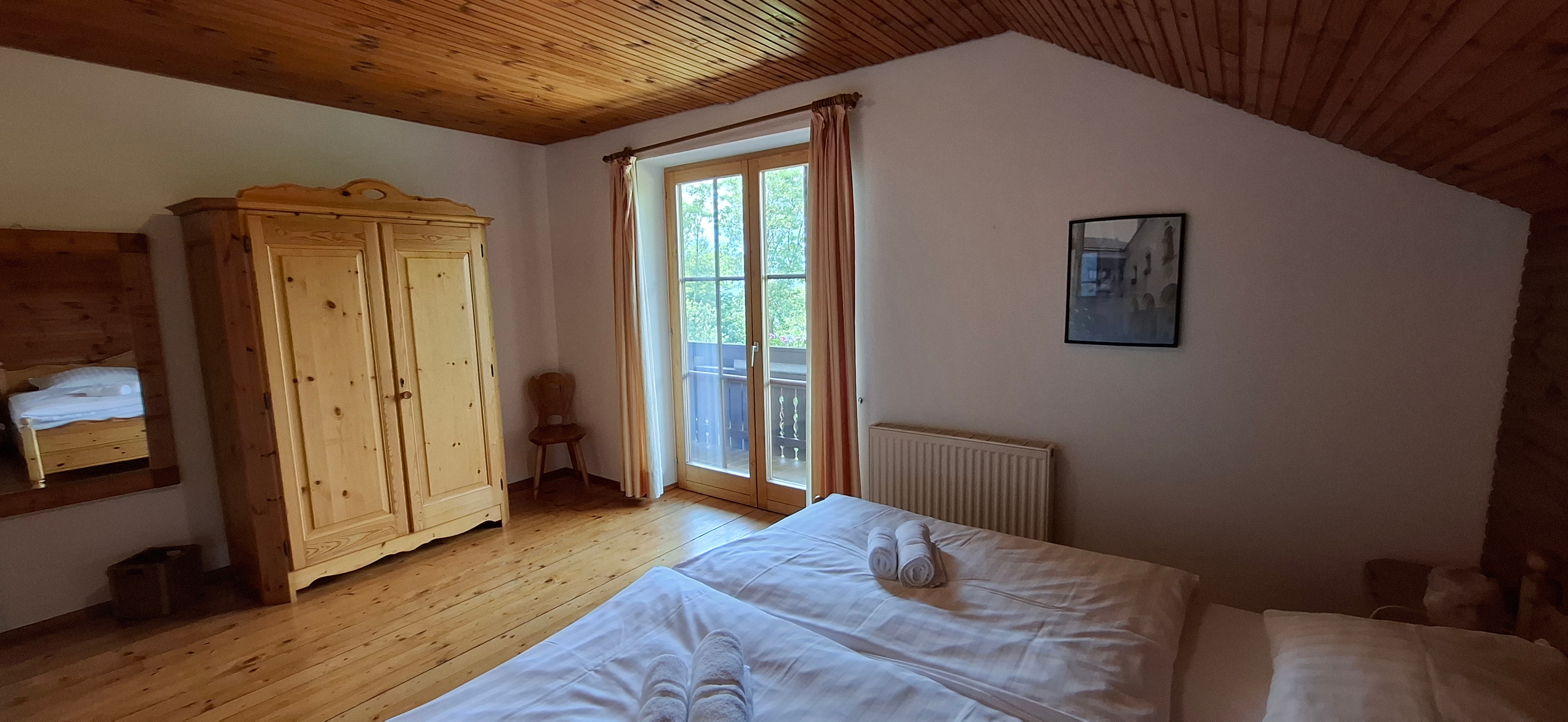 Schlafzimmer mit Balkon und Doppelbett im Obergeschoß
