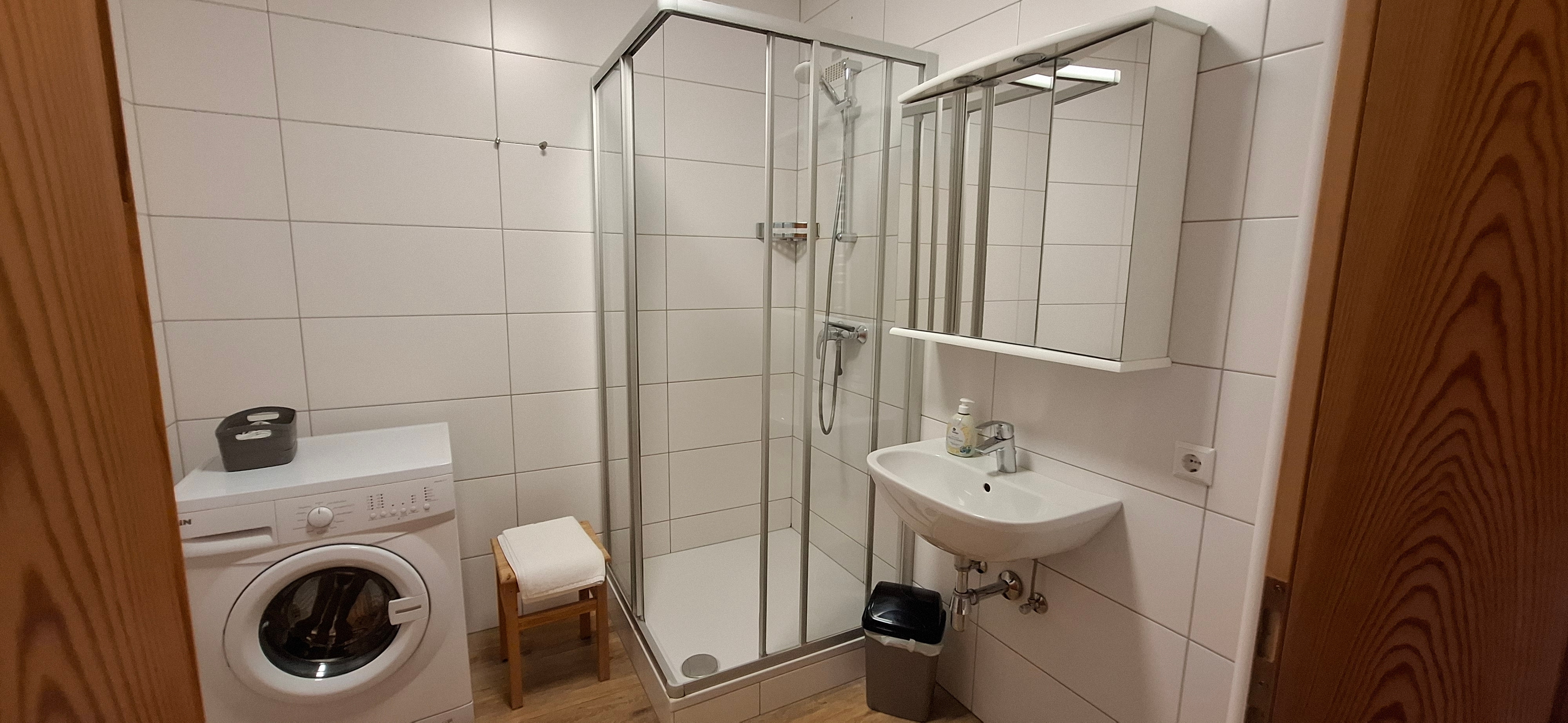 Badezimmer mit Dusche und Waschmaschine