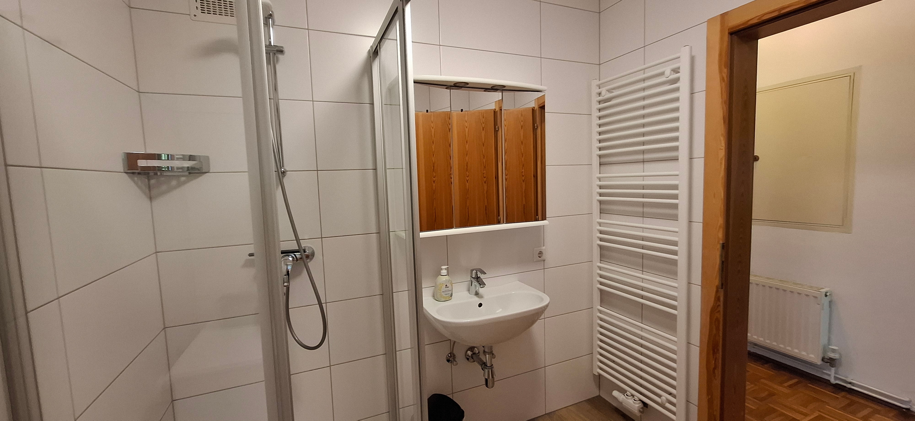 Badezimmer mit Dusche und Waschmaschine